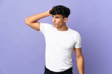 Arjantinli genç adam arka planda izole edilmiş. Kafasını kaşırken şüpheleri var.