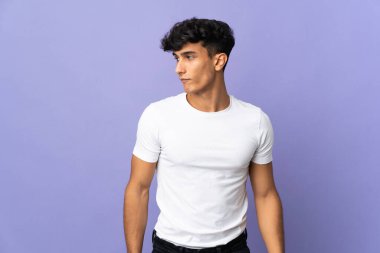 Arjantinli genç adam arka planda izole edilmiş, şüpheli hareketler yapıyor.