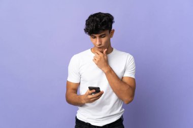 Arjantinli genç adam arka planda izole edilmiş düşünüyor ve bir mesaj gönderiyor.