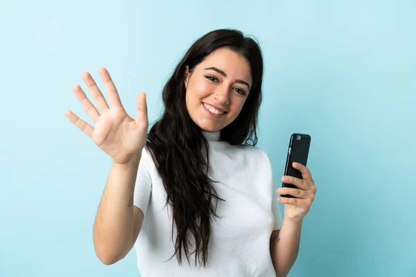 Giovane Donna Utilizzando Telefono Cellulare Isolato Sfondo Blu Saluto Con — Foto Stock