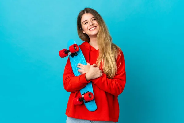 Jovem Loira Isolada Fundo Azul Com Skate Com Expressão Feliz — Fotografia de Stock