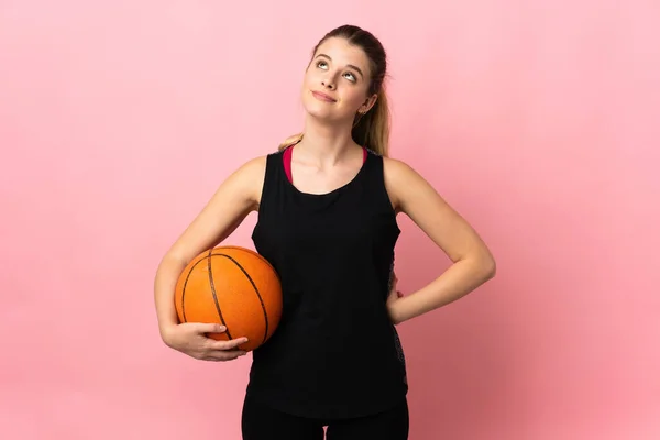 Молодая Блондинка Играет Баскетбол Изолированы Розовом Фоне Глядя Вверх — стоковое фото
