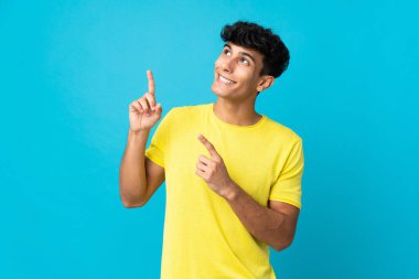 Arjantinli genç adam arka planda izole edilmiş işaret parmağıyla işaret etmek harika bir fikir.