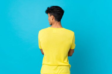 Arjantinli genç adam arka planda izole edilmiş ve yana bakıyor.