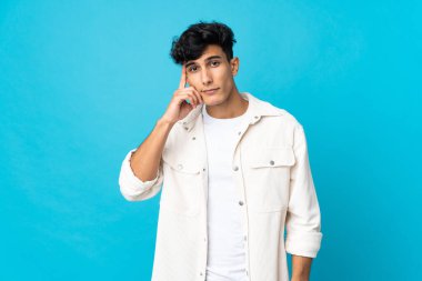 Arjantinli genç bir adam arka planda izole edilmiş bir fikir düşünüyor.