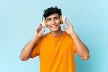 Arjantinli genç adam arka planda izole edilmiş müzik dinliyor.