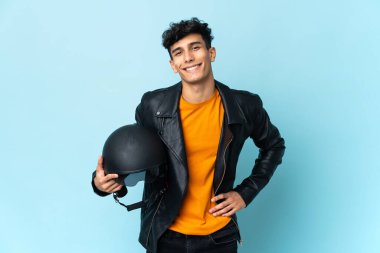 Motosiklet kasklı Arjantinli adam kolları kalçasında poz veriyor ve gülümsüyor