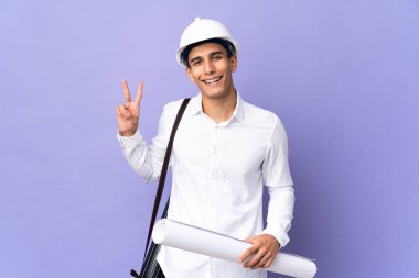 Arka planda izole edilmiş genç mimar gülümsüyor ve zafer işareti gösteriyor.