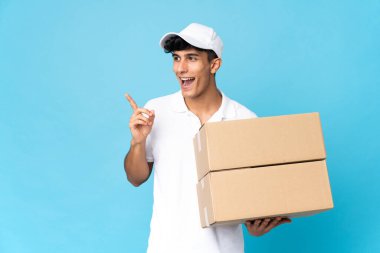 Teslimatçı Arjantinli adam mavi arka planda tek parmağını kaldırarak çözümü bulmaya çalışıyor.