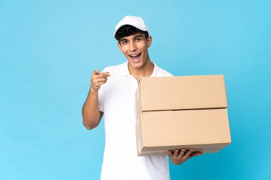 Arjantinli adam mavi arka planda izole edilmiş şaşırmış ve ön tarafı işaret ediyor.