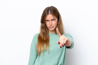 Beyaz arka planda izole edilmiş genç beyaz kadın hayal kırıklığına uğramış ve ön tarafı işaret ediyor.