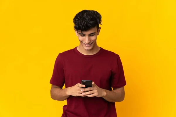 Arjantinli Genç Adam Sarı Arka Planda Izole Edilmiş Cep Telefonuyla — Stok fotoğraf