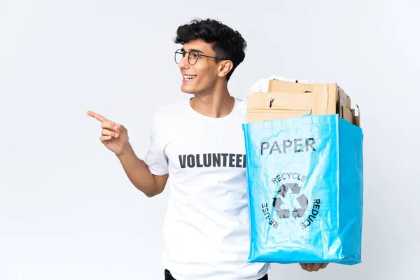 Молодий Чоловік Тримає Мішок Переробки Повний Паперу Вказуючи Пальцем Бік — стокове фото