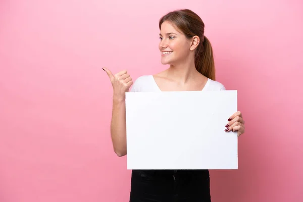 Mulher Caucasiana Jovem Isolado Fundo Rosa Segurando Cartaz Vazio Apontando — Fotografia de Stock