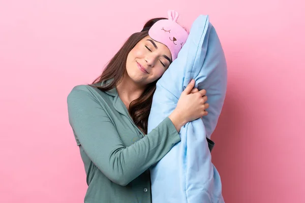 身穿睡衣 穿着粉色背景的巴西年轻女子 抱着一个带着快乐表情的枕头 — 图库照片