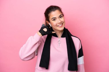 Pembe arka planda izole edilmiş Brezilyalı genç bir kadın telefon jesti yapıyor. Bana geri dönüş işareti ver.