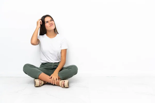 Adolescente Chica Sentada Suelo Teniendo Dudas Con Expresión Cara Confusa — Foto de Stock