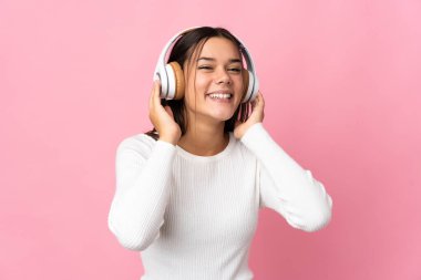 Genç kız mavi arka planda izole edilmiş müzik dinliyor.