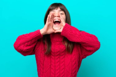 Küçük beyaz kız mavi arka planda izole edilmiş bağırıyor ve bir şeyler söylüyor.