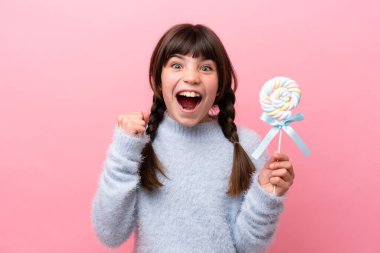 Küçük beyaz kız elinde lolipopla zaferi kutluyor.