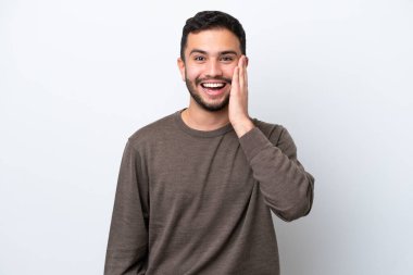 Genç Brezilyalı adam beyaz arka planda izole edilmiş, şaşırmış ve şok olmuş bir yüz ifadesi var.