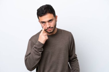 Beyaz arka planda izole edilmiş genç Brezilyalı bir adam bir şey gösteriyor