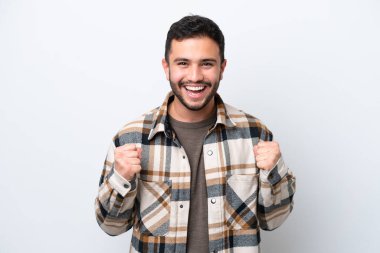 Genç Brezilyalı adam beyaz arka planda tek başına zaferi kutluyor.