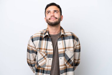 Genç Brezilyalı adam beyaz arka planda izole edilmiş ve yukarı bakıyor.