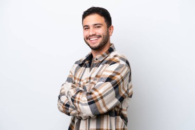 Genç Brezilyalı adam beyaz arka planda izole edilmiş, kolları bağlı ve ileriye bakıyor.