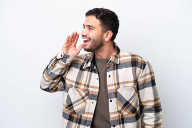 Beyaz arka planda izole edilmiş genç Brezilyalı adam ağzı sonuna kadar açık bağırıyor.