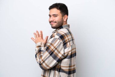 Genç Brezilyalı bir adam beyaz arka planda bir şeyler planlıyor.