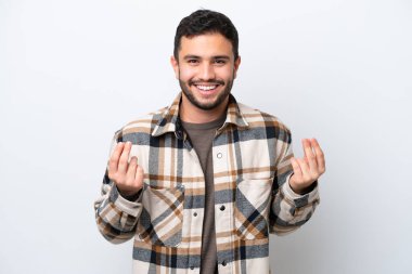 Beyaz arka planda izole genç Brezilyalı adam para hareketi yapıyor.