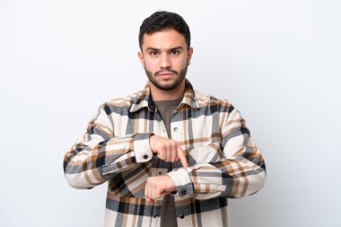 Genç Brezilyalı adam beyaz arka planda izole edilmiş, geç kalma jesti yapıyor.