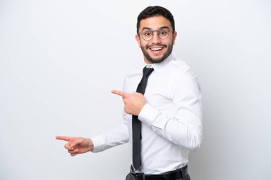 Beyaz arka planda izole edilmiş Brezilyalı adam şaşırmış ve işaret ediyor.