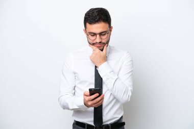 Brezilyalı iş adamı beyaz arka planda izole edilmiş düşünüyor ve bir mesaj gönderiyor.