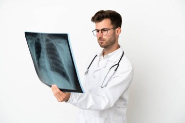 Beyaz arka planda izole edilmiş, doktor önlüğü giymiş ve elinde kemik taraması yapan genç bir doktor.