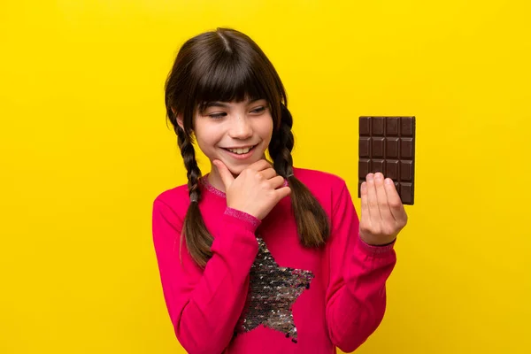 Malá Kavkazská Dívka Čokoládou Izolované Žlutém Pozadí Dívá Strany Usmívá — Stock fotografie
