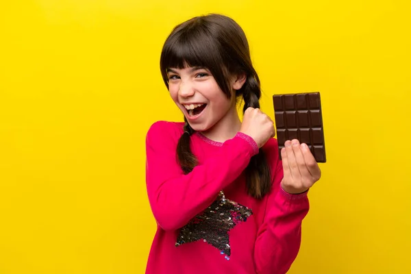Malá Kavkazská Dívka Čokoládou Izolované Žlutém Pozadí Slaví Vítězství — Stock fotografie