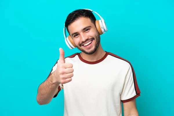 Jonge Braziliaanse Man Geïsoleerd Blauwe Achtergrond Luisteren Muziek Met Duim — Stockfoto
