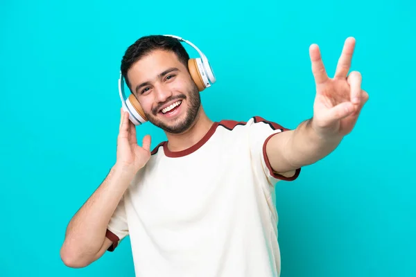 Genç Brezilyalı Adam Mavi Arka Planda Izole Edilmiş Müzik Dinliyor — Stok fotoğraf