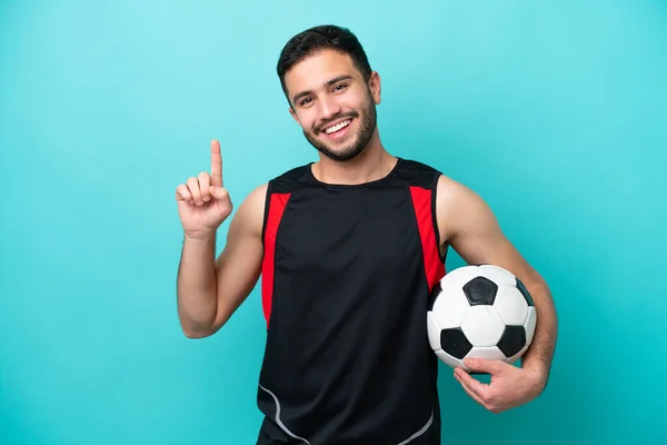 Jonge Voetballer Braziliaanse Man Geïsoleerd Blauwe Achtergrond Tonen Tillen Van — Stockfoto