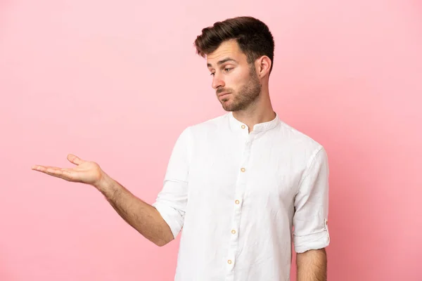 Jonge Blanke Knappe Man Geïsoleerd Roze Achtergrond Houden Copyspace Met — Stockfoto