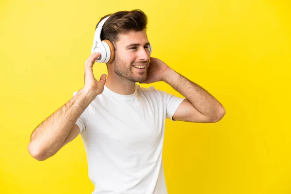 Νεαρός Καυκάσιος Όμορφος Άνδρας Απομονωμένος Κίτρινο Φόντο Ακούγοντας Μουσική Και — Φωτογραφία Αρχείου