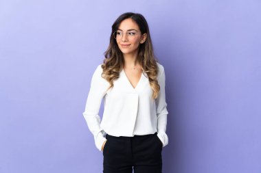 Mor arka planda izole edilmiş genç beyaz kadın şüpheli hareketler yapıyor.