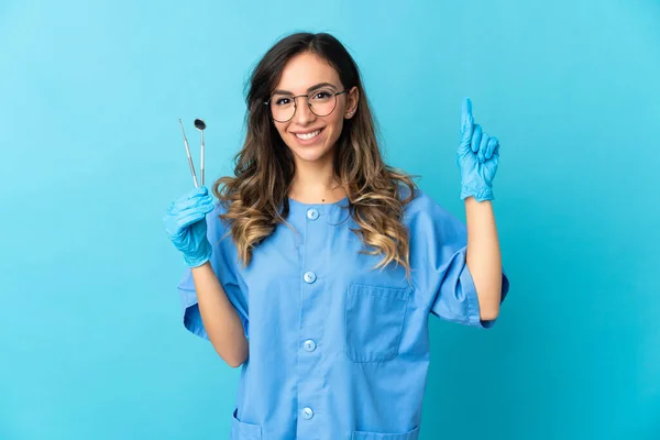 Zahnärztin Hält Werkzeug Über Isoliert Auf Blauem Hintergrund Auf Eine — Stockfoto