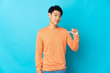 Mavi arka planda kendini beğenmiş ve gururlu genç bir Çinli.