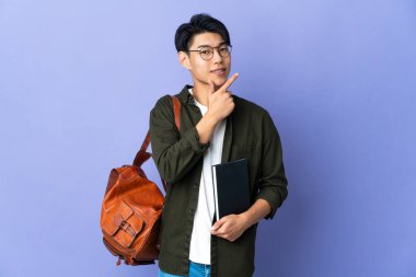 Mor arka planda izole edilmiş genç kız mutlu ve gülümsüyor.