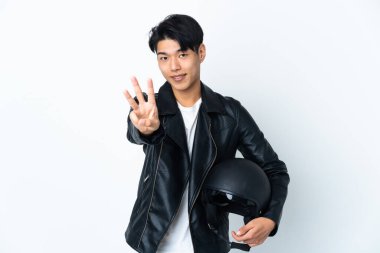 Motosiklet kasklı Çinli adam beyaz arka planda izole edilmiş mutlu ve parmaklarıyla üçe kadar sayıyor.