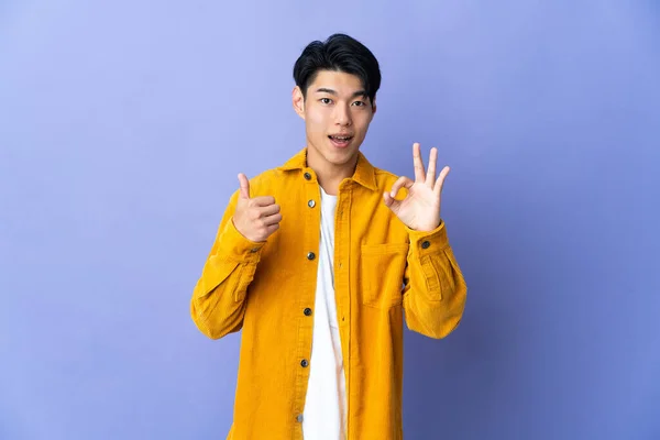 Молодий Китайський Чоловік Ізольований Пурпуровому Фоні Показує Добре Видно Знак — стокове фото
