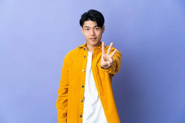 Молодой Китаец Изолированный Фиолетовом Фоне Счастлив Считает Троих Пальцами — стоковое фото
